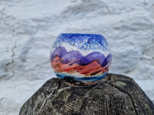 Load image into Gallery viewer, A globe tealight holder with the hills and the sea painted on it.