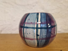 Load image into Gallery viewer, A cylindrical tealight holder on a wooden surface woth a stone wall behind it
