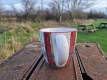 Load image into Gallery viewer, a mug with the handle facing the camera. Trees and grass in the background.