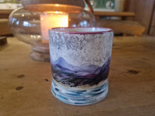 Load image into Gallery viewer, Ceramic cup with mountain design on a wooden surface with a candle in the background
