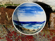 Load image into Gallery viewer, Ceramic bowl with a scenic design of a beach and blue sky on a textured surface.
