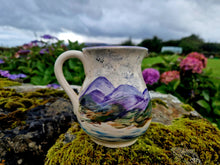 Load image into Gallery viewer, A jug painted with the ills and sea, sat on a wall covered in moss. Hydrangea flowers in the background
