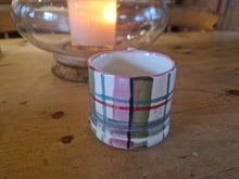 Load image into Gallery viewer, Small plaid ceramic cup on a wooden surface with a candle in the background
